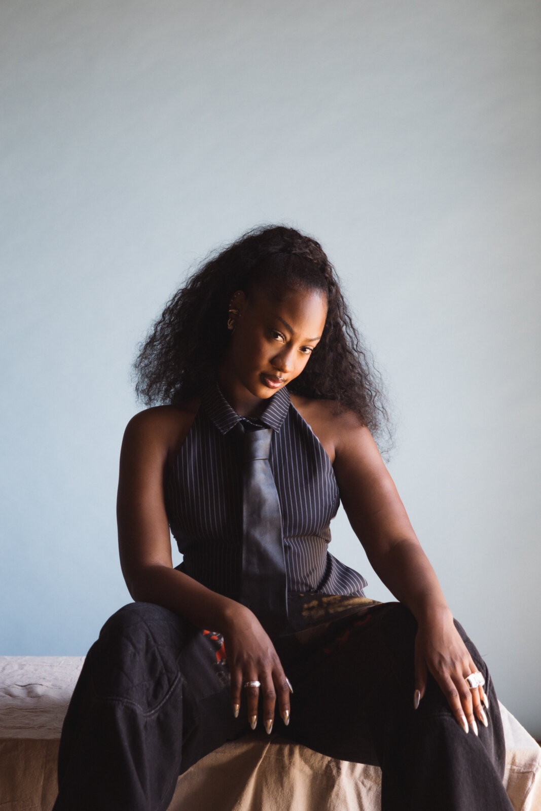 A portrait of Tems sitting down.