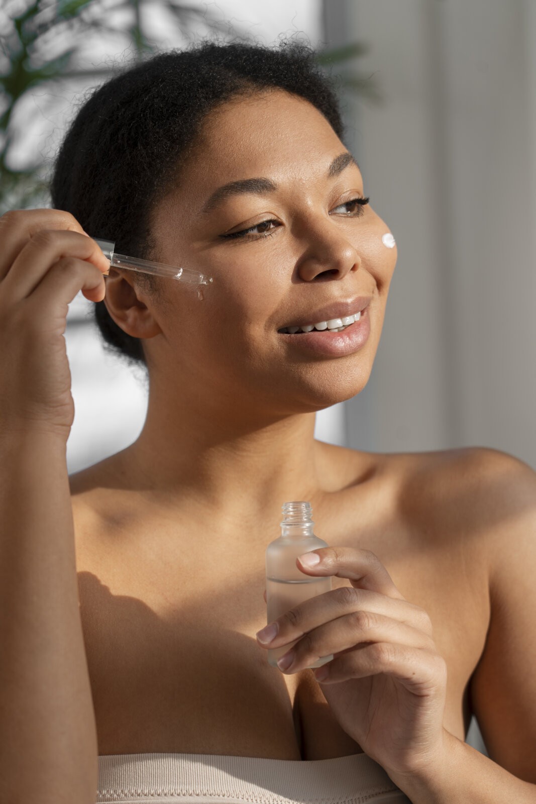 Ninacinamide -Black woman applying a serum to her face via Freepik