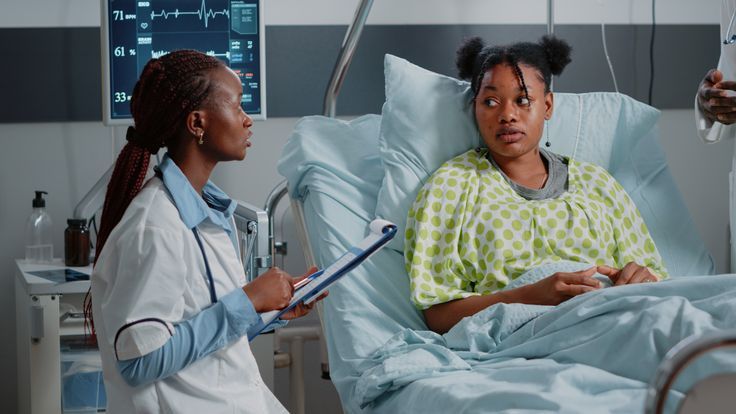 A Black female doctor consulting with a female patient in a hospital by Christopher Salas via Pinterest.