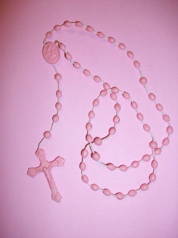 Pink Rosary on a pink backdrop via Pinterest 