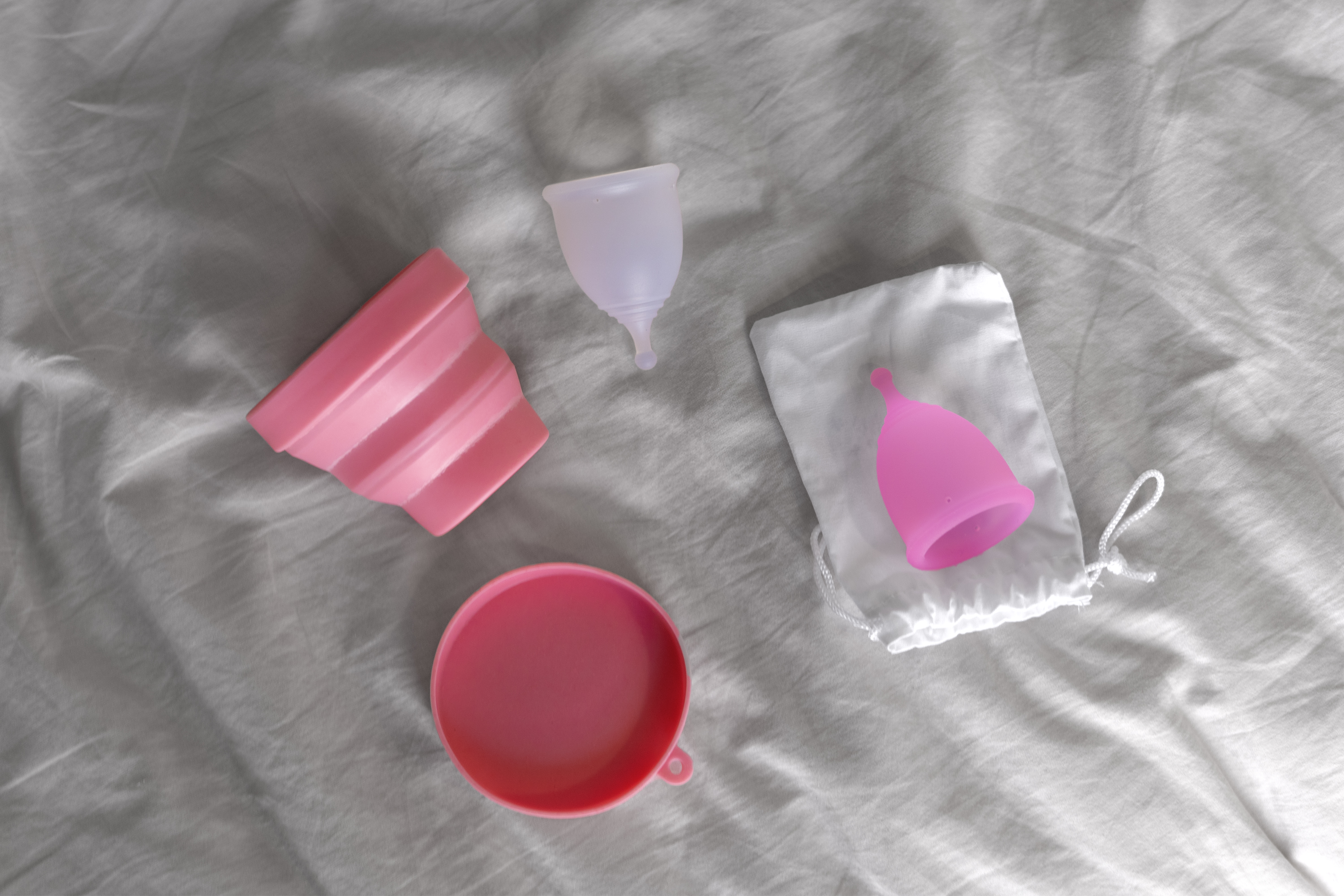Menstrual cups, a storage pouch and a steriliser via Freepik