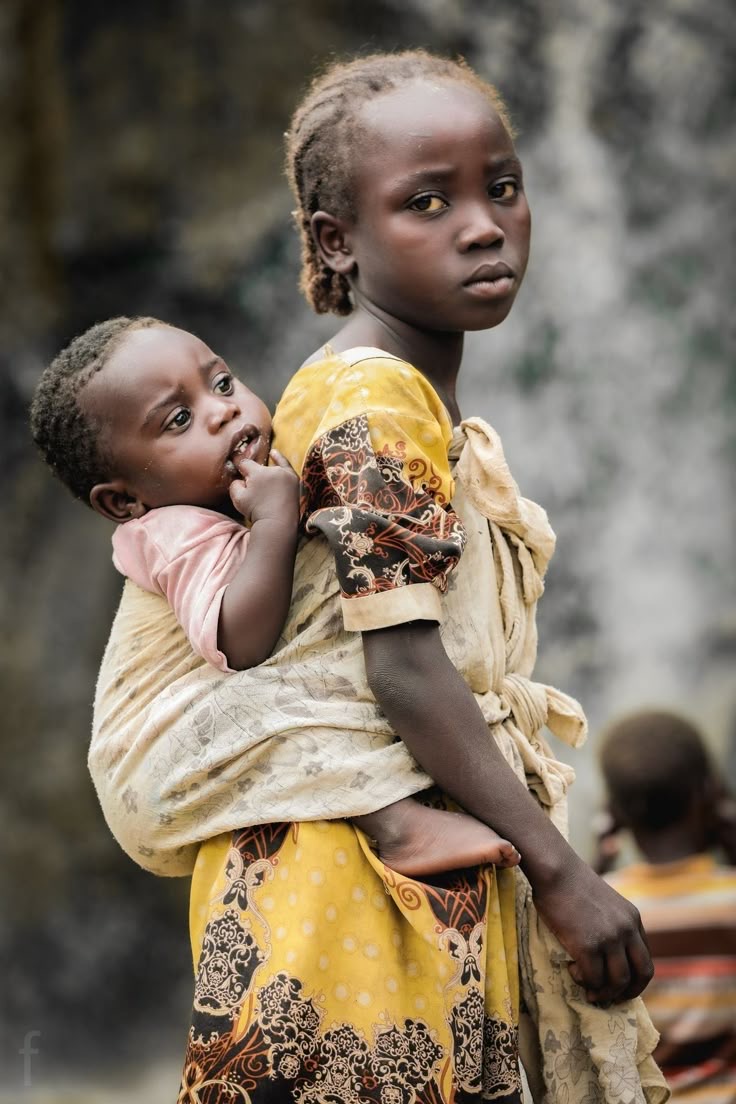 Little girl carrying a baby on her back via Pinterest (original creator unknown). If this is your work, please contact us for credit.)