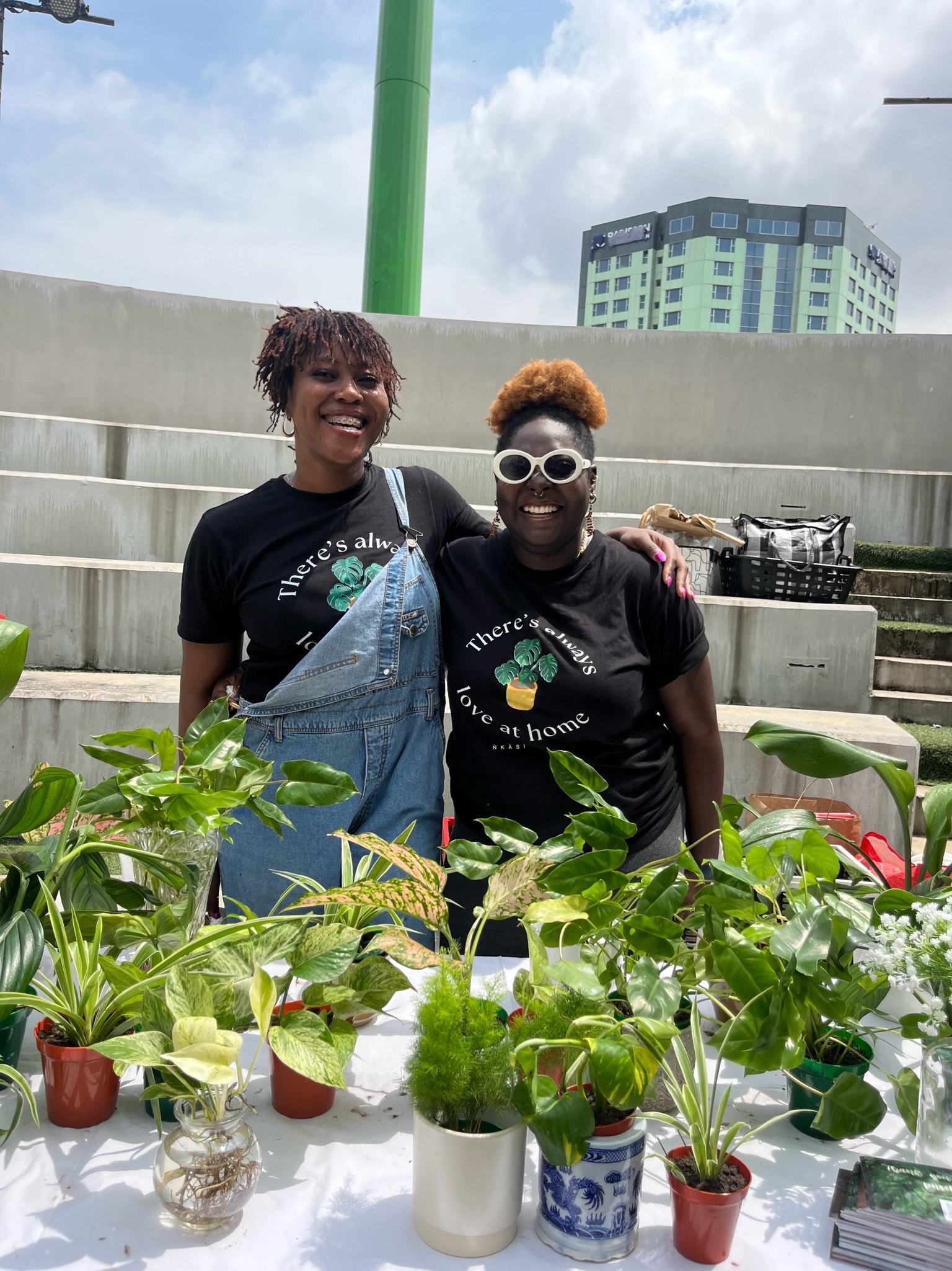 Founders of Nkasi Obi Tobi and Ifeoma in front of potted plants via Tobi Afolabi 