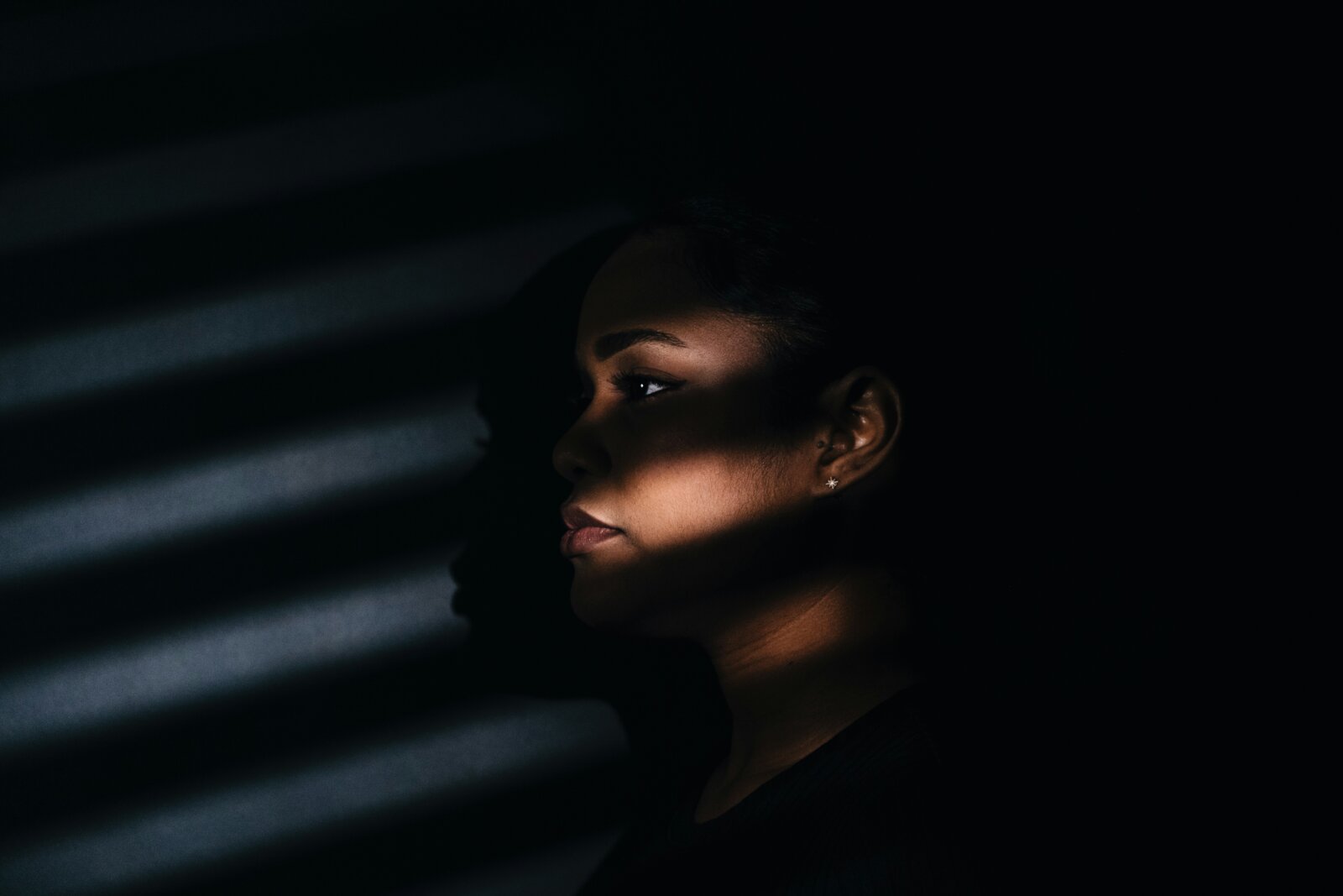 Black woman in the shadow, photograph by Dmitrii Shirin via Unsplash neutral 