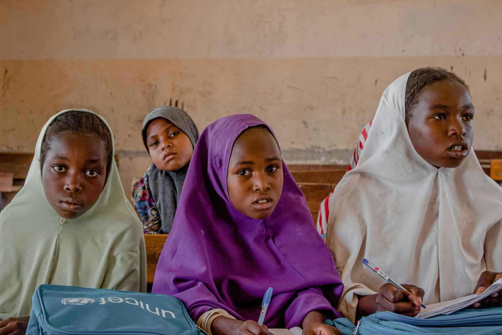 Girl Education: Girls in hijab with bags from UNICEF sitting in a classroom by Musa Ajit via Unsplash
