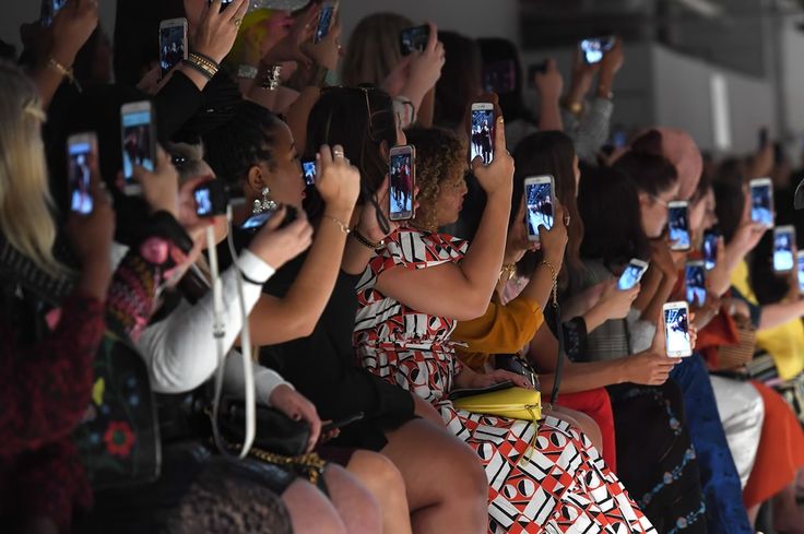 A group of people taking runway photos with their iPhones via Pinterest 