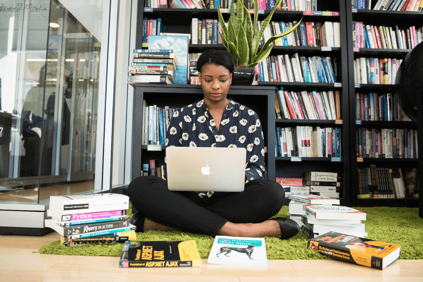 Woman surrounded by books while working via Unsplash