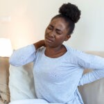 A black girl with back pain via Freepik