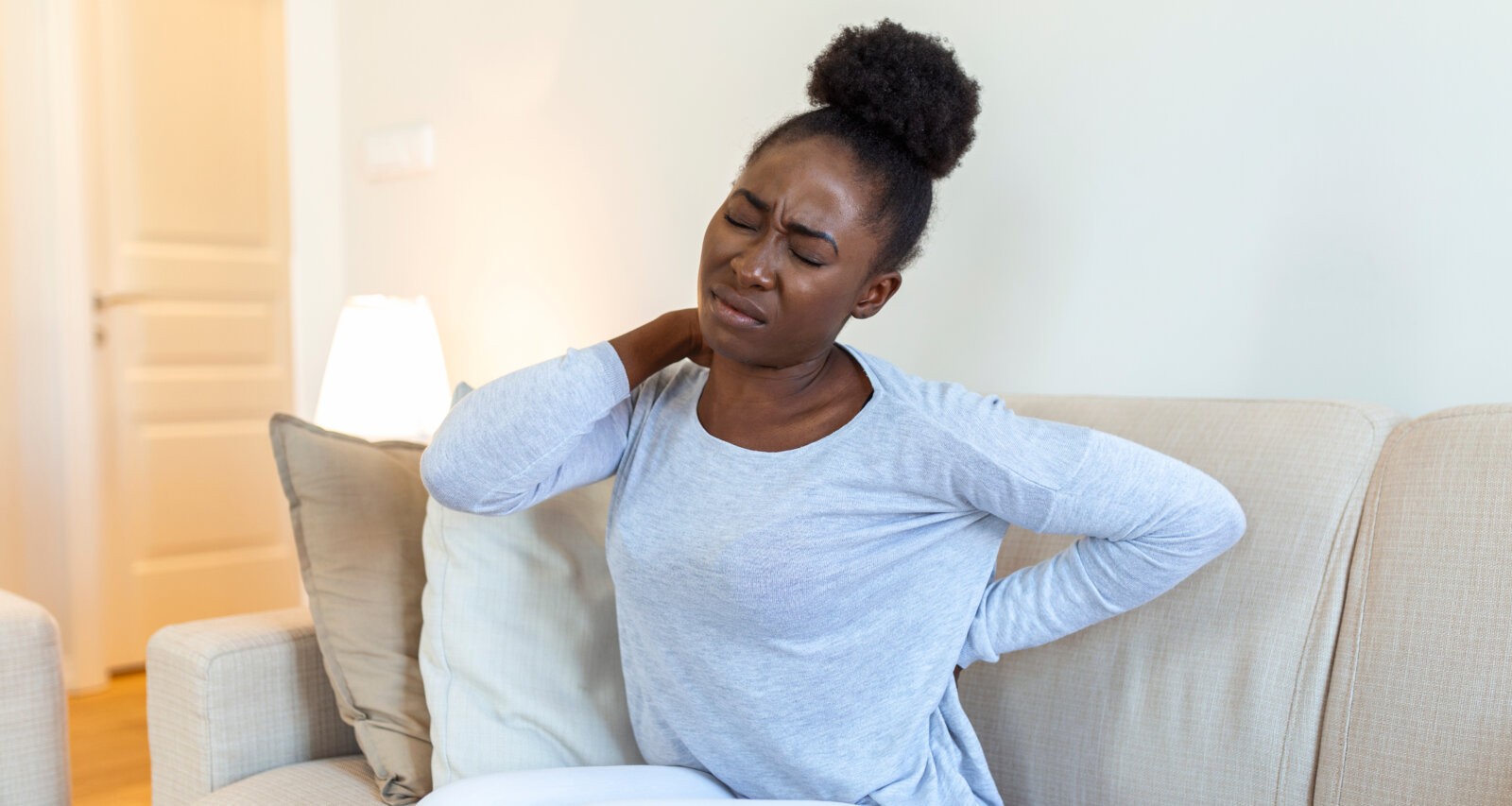 A black girl with back pain via Freepik