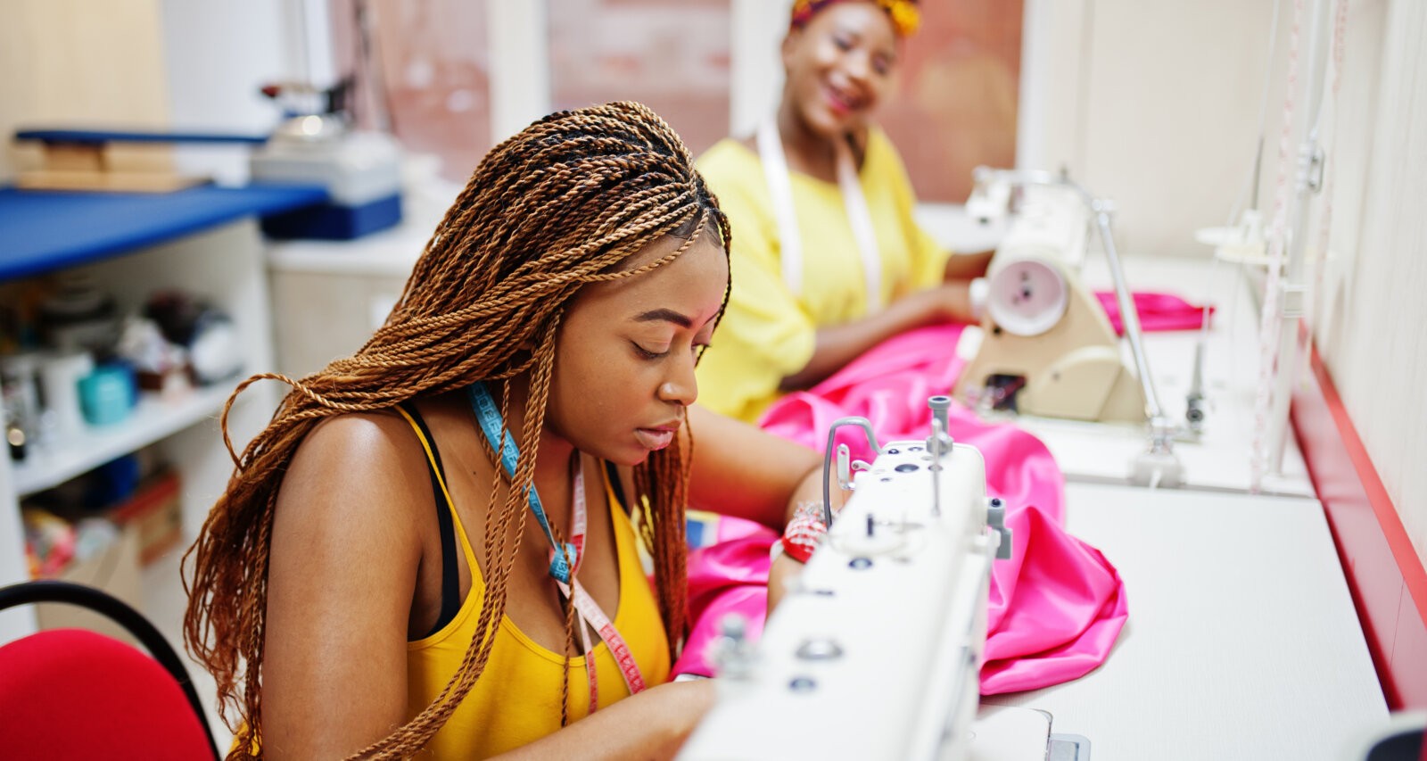 Custome-made wear: Two African women sewing cloth with a sewing machine via Freepik.