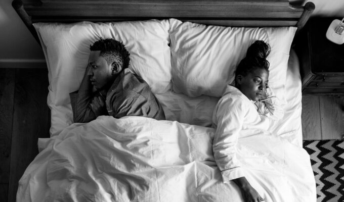 Cheating dreams: A couple backing each other in bed.