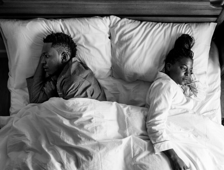 Cheating dreams: A couple backing each other in bed.