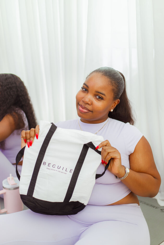 A guest at "Breathe In Beguile" via Beguile by Omaa. She is wearing a lilac two piece and is holding a white bag