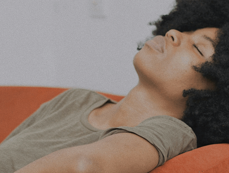 A Black woman laying on a couch by Baptiste Ime via Unsplash+