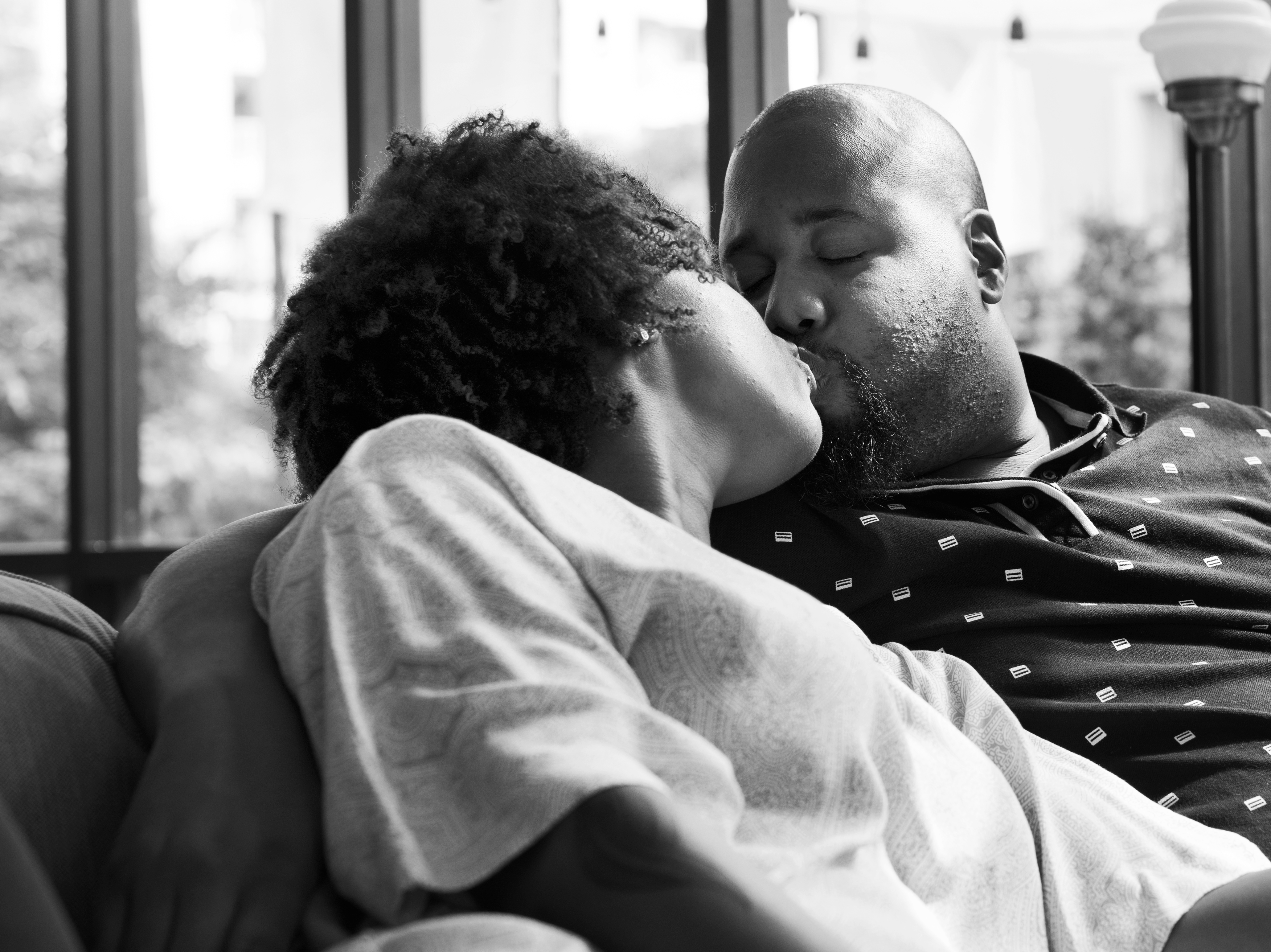 Black couple kissing on the couch via Freepk