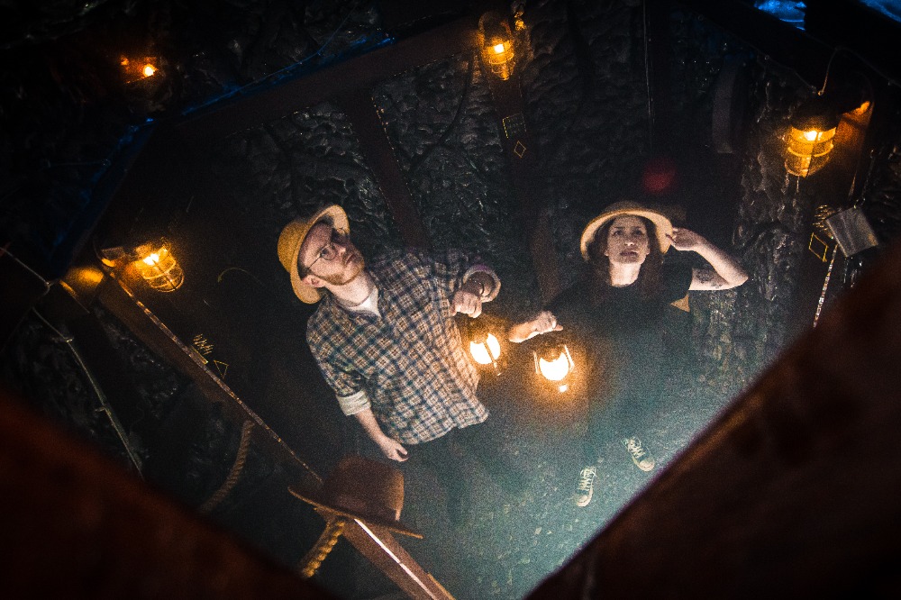 2 players look up for a clue in the explorers diary escape room