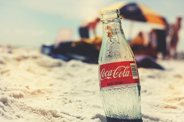 Coca cola glass bottle on a beach