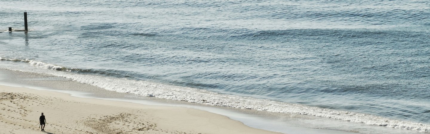 People walking on beach calm waves