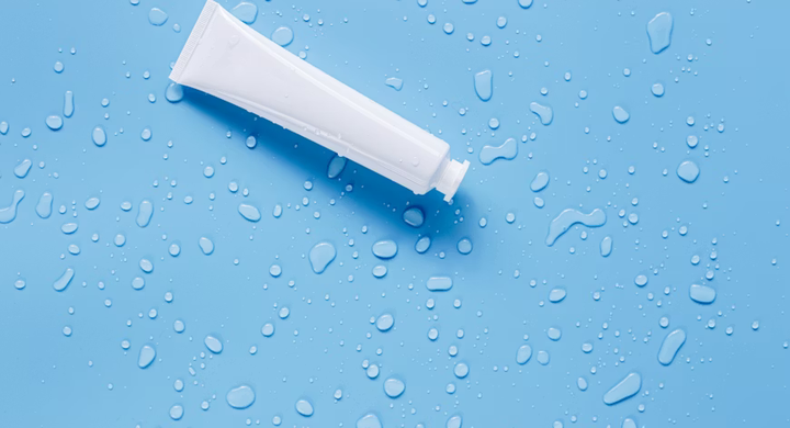 Cosmetic tube on water drop background