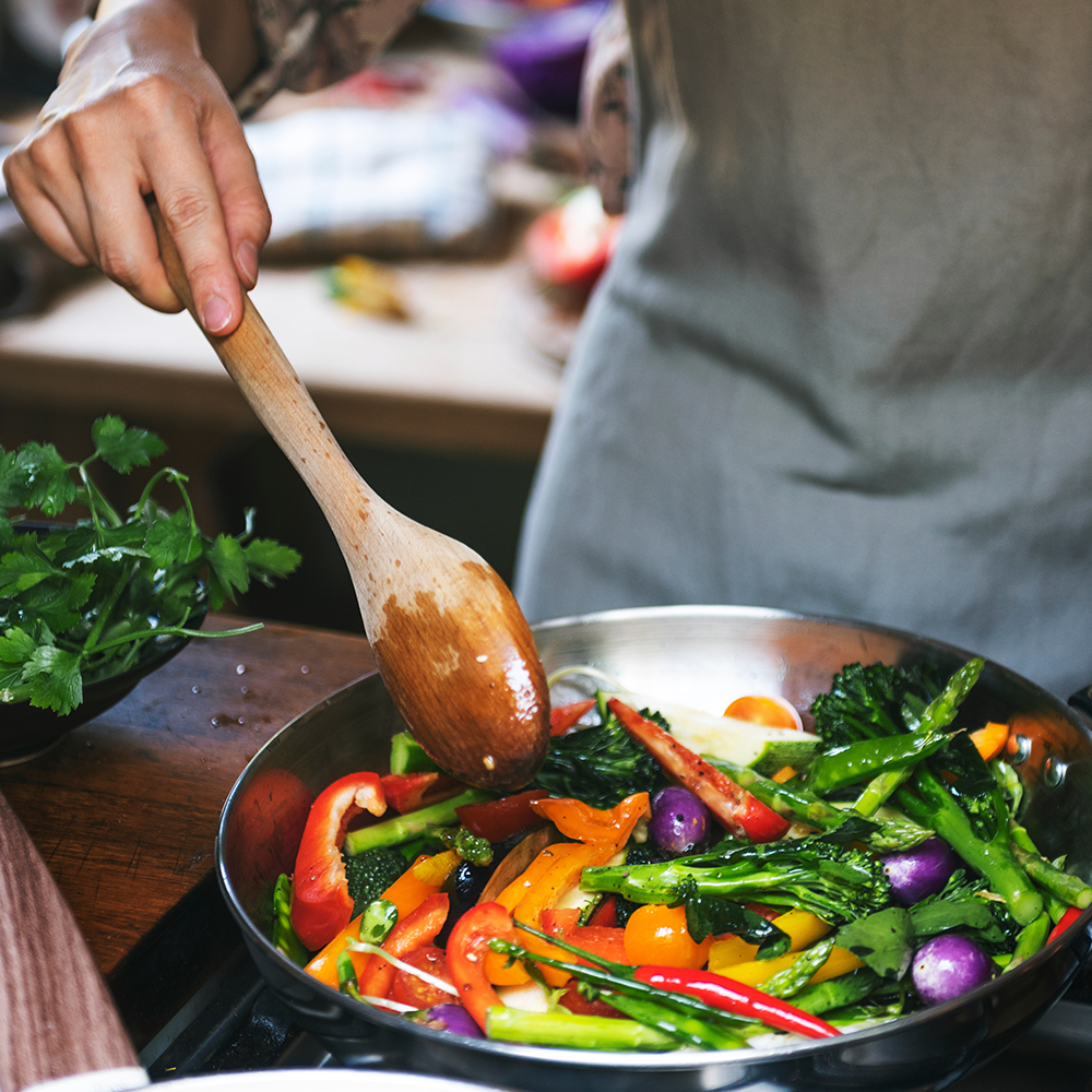 Person cooking vegetables in a pan
