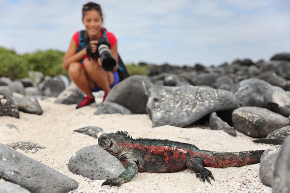 A tourist in the Galapagos with a camera, a key item on your cruise packing list