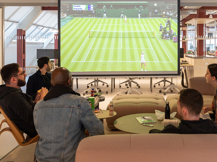Social room in our new London HQ with several staff members relaxing after work.