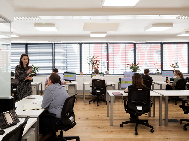 Horizontal shot showing various staff members working at the London office.