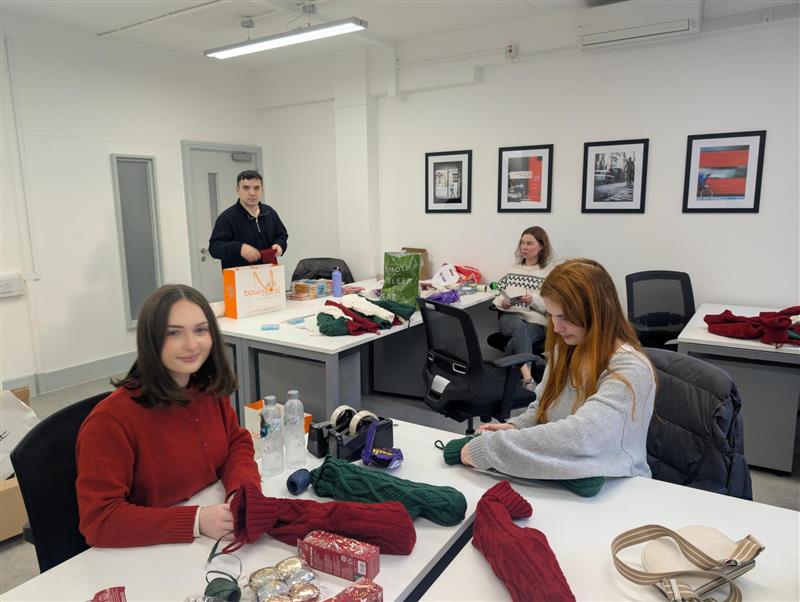 A group of our staff members wrapping gifts as part of our charity work.