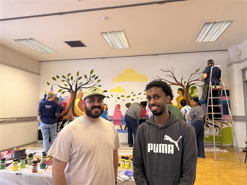 A group of our staff members collaborating on a mural as part of volunteering work.