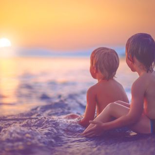 boys on a beach at sunset