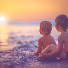 boys on a beach at sunset