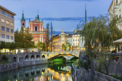 beautiful photograph of buildings and a bridge in ljubljana at dusk