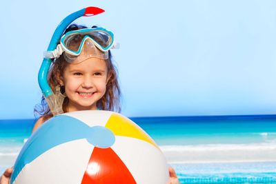 a happy young girl with a large beach ball
