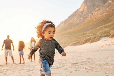 young girl playing and running on the beach
