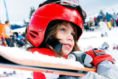 a child carrying a pair of skis
