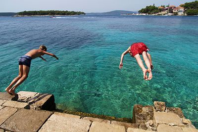 boys diving into the sea