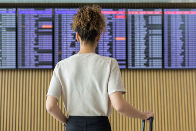 Girl looking at airport departure board