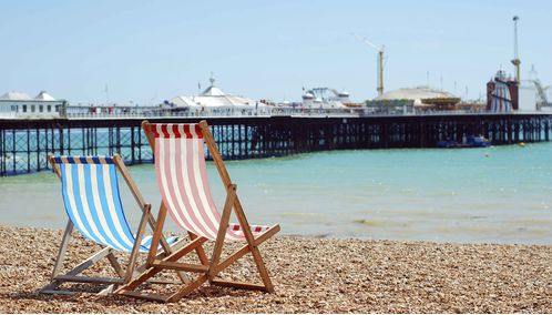 Two deckchairs overlooking Brighton Pier