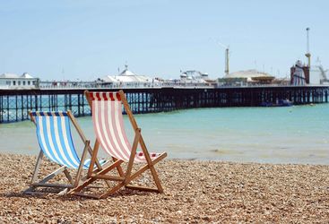 Two deckchairs overlooking Brighton Pier