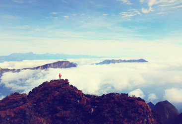 Travellers stands on top of a mountain