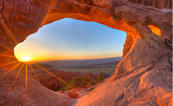 Sun rising through an arch