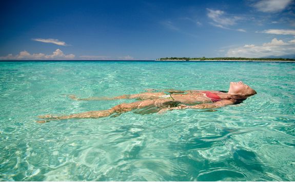 A woman relaxing in the ocean at Lombok beach