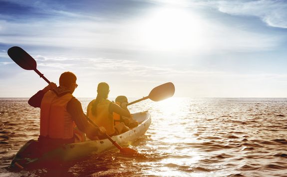 Family kayaking at sunset