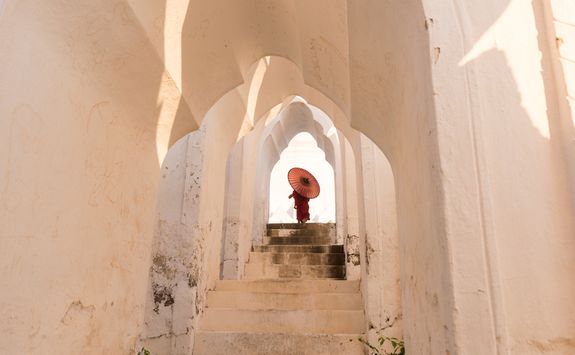 Mandalay Monk walking up white stairs