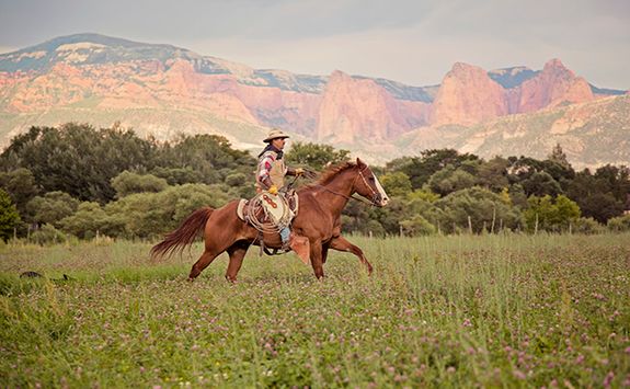 gaucho riding with mountains behind