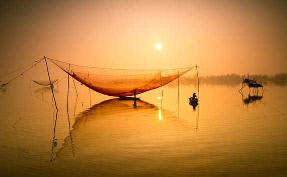 Fishermen with nets at sunset