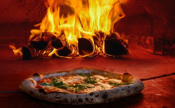 cooking pizza in a pizza oven