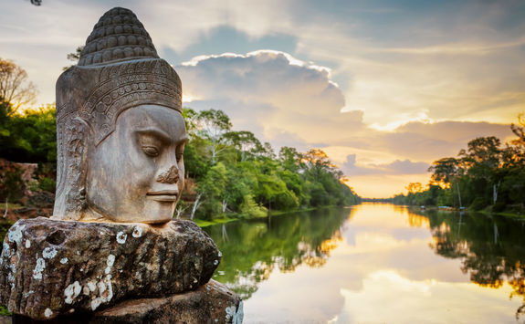 Stone face Asura and sunset over Angkor Thom