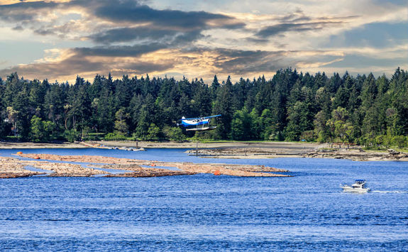 Float plane flying over a fishing boat