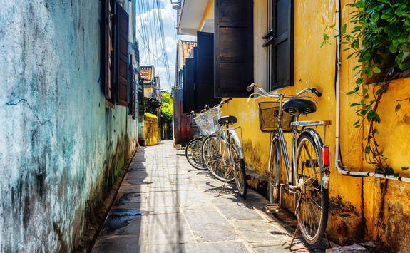 bicycles parked near yellow wall